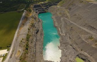 A view of a quarry with water at the bottom